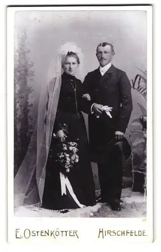 Fotografie E. Ostenkötter, Hirschfelde, Portrait Brautpaar in schwarzer Festkleidung mit Blumenstrauss