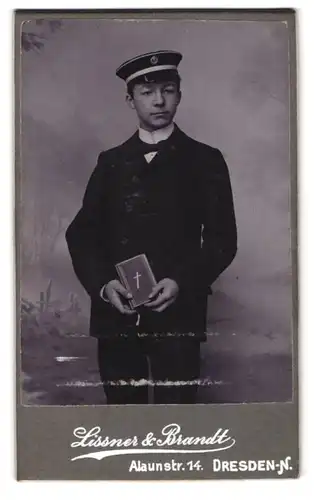 Fotografie Lissner & Brandt, Dresden, Alaunstr. 14, Portrait Student im Anzug mit Bibel, Mütze mit Verbindungsabzeichen