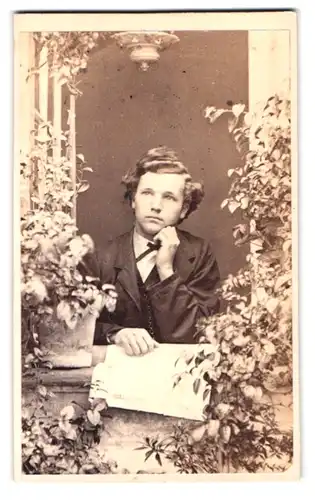 Fotografie unbekannter Fotograf und Ort, Portrait Bursche mit Zeitung am Fenster stehend
