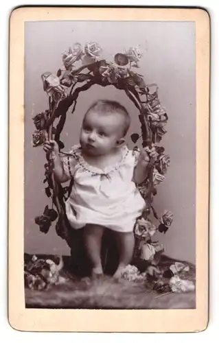 Fotografie Atelier Louvois, Bruxelles, 51 Chaussee de Louvain, Baby von Rosen umrankt