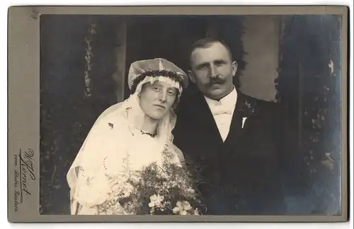 Fotografie W. Kornet vorm. Schulze, Bautzen, Portrait junges Paar in Hochzeitskleidung mit Schleier und Blumenstrauss