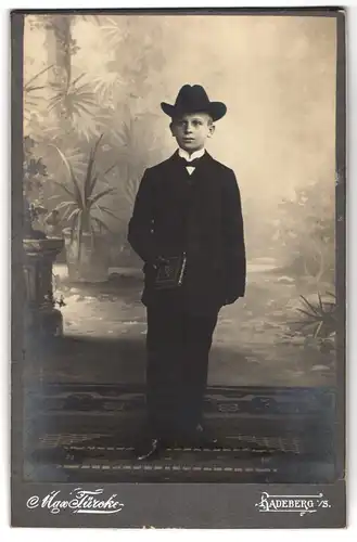 Fotografie Max Türcke, Radeberg i /S, Portrait Junge im Anzug mit Buch