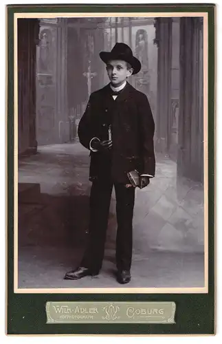 Fotografie Wilh. Adler, Coburg, Portrait Junge im Anzug mit Buch