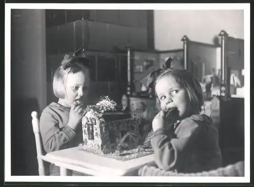 Fotografie niedliche Mädchen naschen vom Lebkuchenhaus