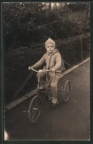 Fotografie Knabe fährt auf Fahrrad - Dreirad