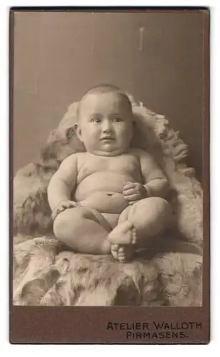 Fotografie Fritz Walloth, Pirmasens, Portrait nackiges Kleinkind auf Fell sitzend