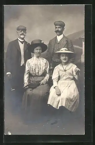 Foto-AK Familie in Sonntagskleidern vor einer Studiokulisse