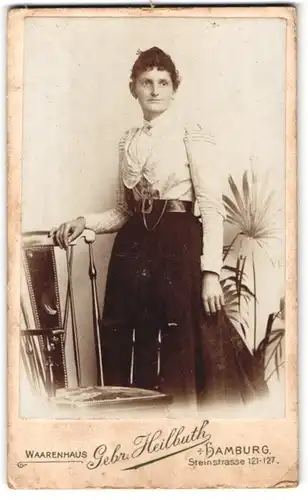 Fotografie Gebr. Heilbuth, Hamburg, Steinstrasse 121-127, Frau mit Locken in modischer Karobluse mit Rock und Gürtel