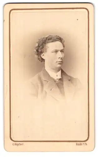 Fotografie C. Höpfner, Halle a/S., Mann mit ernstem Blick und langem Haar in einem Sacko