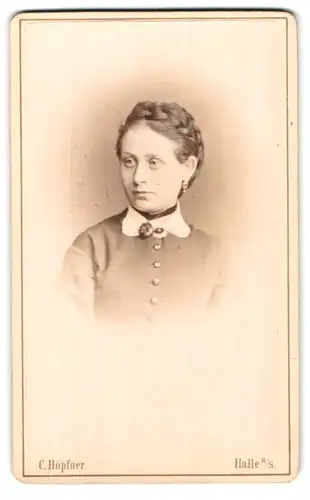 Fotografie C. Höpfner, Halle a/S., Frau mit geflochtenem Zopf und Brosche in geknöpftem Kleid