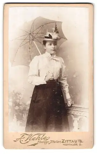 Fotografie A. Wehle, Zittau, Hospitalstrasse 2, Junge Frau mit geschmücktem Hut in Bluse und Rock mit Karoschirm