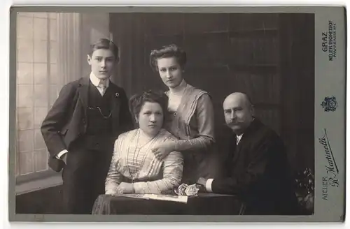 Fotografie R. Martinelli, Graz, Neuer Thonethof, Portrait Familienfoto vor einer Bücherregal Kulisse