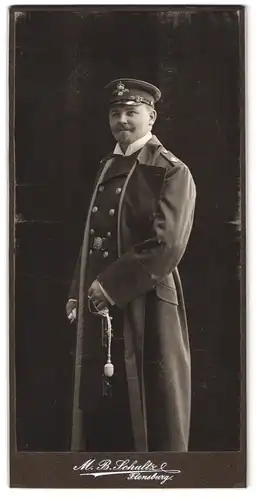 Fotografie M. B. Schultz, Flensburg, Offz. Kaiserliche Marine in Uniform mit Mantel, Degen und Portepee