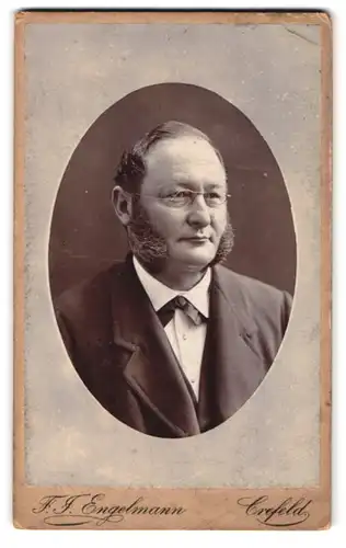 Fotografie F. J. Engelmann, Crefeld, Westwall 73, Portrait rundlicher Mann mit Backenbart und Brille trägt Anzug