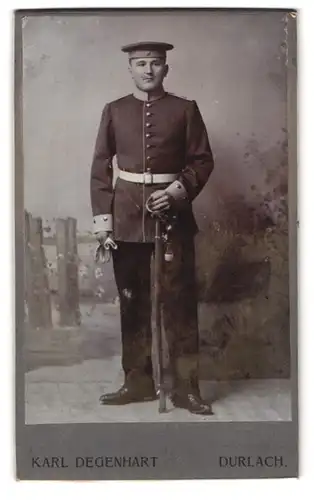 Fotografie Karl Degenhart, Durlach, Portrait Soldat mit Uniformmütze und Degen mit Portepee