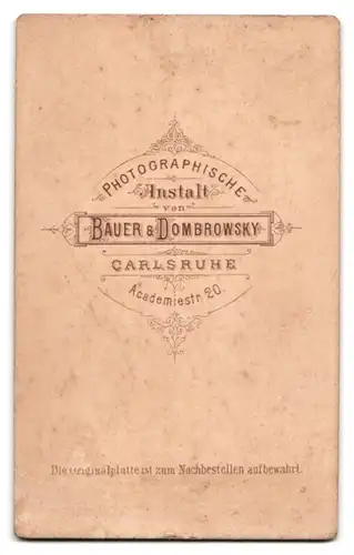 Fotografie Bauer & Dombrowsky, Karlsruhe, Academiestr. 20, Portrait Musiker der Garde mit Uniformmütze, Schwalbennester