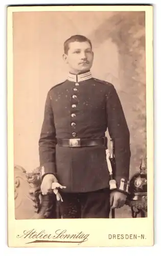 Fotografie Atelier Sonntag, Dresden-N., Alaunstrasse 14, Portrait sächsischer Gardesoldat, Pickelhaube auf Tisch liegend