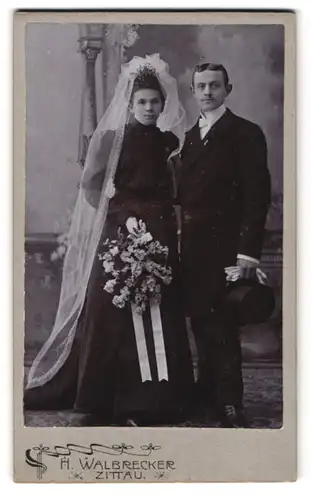 Fotografie H. Waldbrecker, Zittau, Theodor Körner Allee, Portrait Ehepaar im schwarzen Kleid mit Schleier und Zylinder