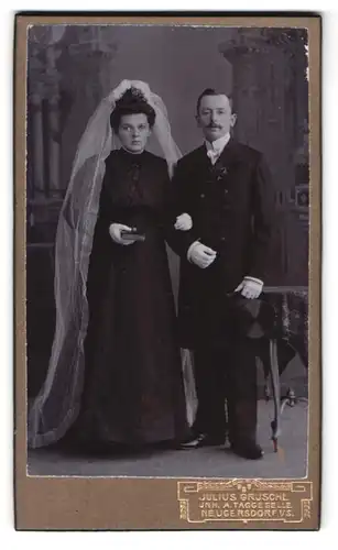 Fotografie Julius Grusche, Neugersdorf i. S., Portrait junges Ehepaar im schwarzen Kleid mit Schleier und Zylinder