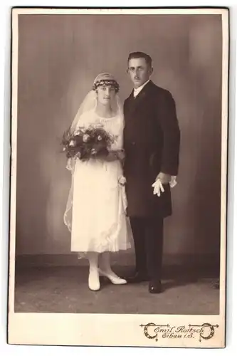 Fotografie Emil Rortsch, Eibau i. S., Portrait junges Ehepaar beim Hochzeitsfoto im weissen Kleid mit Zylinder