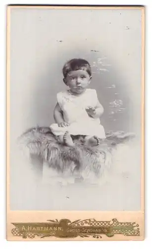 Fotografie A. Hartmann, Gross-Schönau i. S., Portrait niedliches Kleinkind im weissen Kleid mit nackigen Füssen
