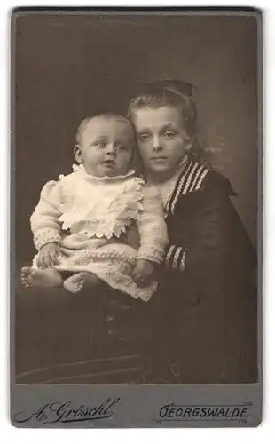 Fotografie Alfred Gröschl, Georgswalde, i. Böhmen, Portrait kleines Mädchen im Matrosenkleid mit Kleinkind