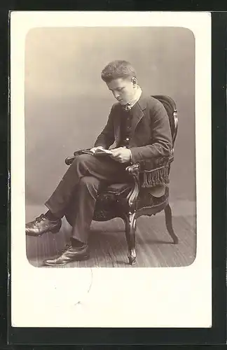 Foto-AK Lesender junger Mann im Anzug