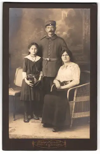 Fotografie Atelier Hauschild, Zittau i/S., Reichenbergstrasse 28, Portrait Soldat in Feldgrau mit Frau und Tochter