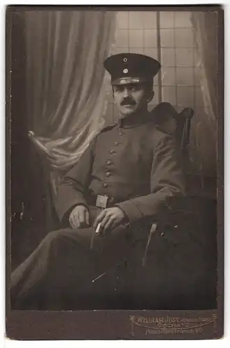 Fotografie William Just, Oschatz, Hospitalstrasse 40, Portrait Soldat in Feldgrau mit Zigarette