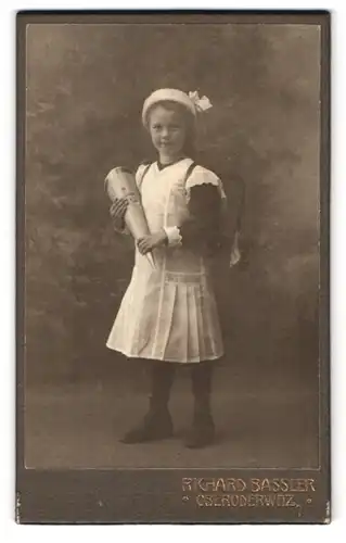 Fotografie Richard Bassler, Oberoderwitz, Portrait kleines Mädchen mit Zuckertüte und Ranzen im weissen Kleid