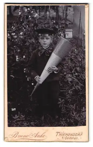 Fotografie Bruno Anke, Thiemendorf, Portrait Junge mit Zuckertüte steht im Garten