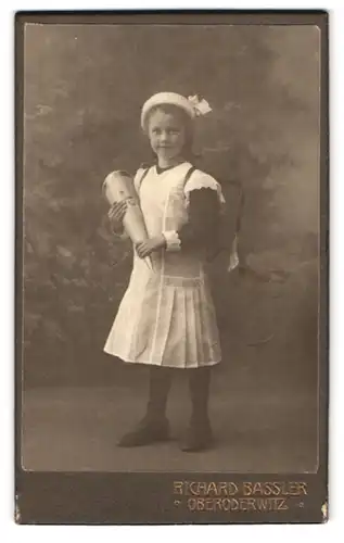 Fotografie Richard Bassler, Oberoderwitz, Portrait Mädchen im weissen Kleid mit Zuckertüte und Ranzen