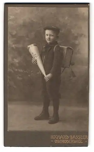 Fotografie Richard Bassler, Oberoderwitz, Portrait Junge mit Zuckertüte und Schulranzen vor einer Studiokulisse