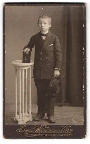 Fotografie Emil Winzer u. Sohn, Potschappel, Tharandterstr., Portrait Junge im feinen Anzug mit Bibel und Hut