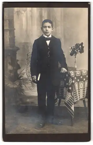 Fotografie Fotograf und Ort unbekannt, Portrait Junge im Anzug mit Bibel zur Konfirmation 1918