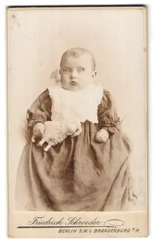 Fotografie Friedrich Schroeder, Berlin, Leipzigerstr. 63a, Baby mit Spielzeug-Schaf macht dicke Backen