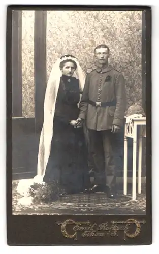 Fotografie Emil Rotsch, Eibau i. S., Soldat in Feldgrau Uniform, Braut im schwarzen Kleid, Kriegshochzeit, Pickelhaube