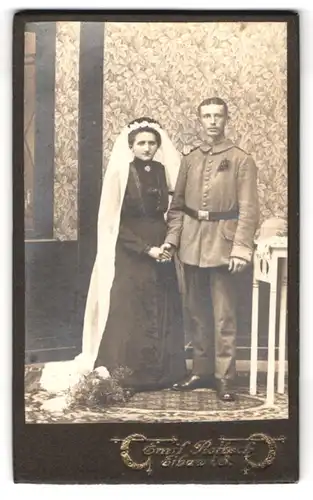 Fotografie Emil Rotsch, Eibau, Soldat in Feldgrau Uniform mit Braut im schwarzen Kleid, Kriegshochzeit