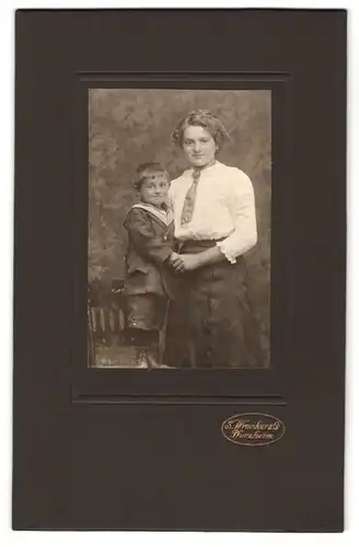 Fotografie S. Wronker & Co., Pforzheim, Portrait stolze junge Mutter hält frechen Buben an der Hand