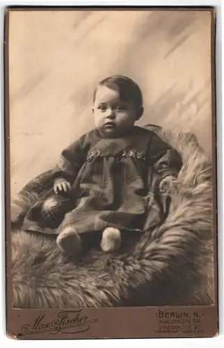 Fotografie Max Fischer, Berlin, Invaliden Str. 164, Kleinkind in Tartankleidchen auf einem Fell