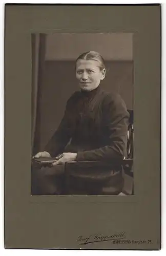 Fotografie Josef Knippschild, Heidelberg, Hauptstr. 25, Dame in schwarzem Kleid sitzt mit Buch in der Hand auf Stuhl