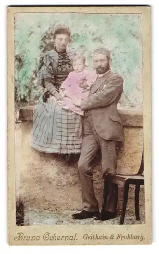 Fotografie Bruno Orchernal, Geithain, Familie mit Kind in einem rosa Kleidchen an einer Mauer