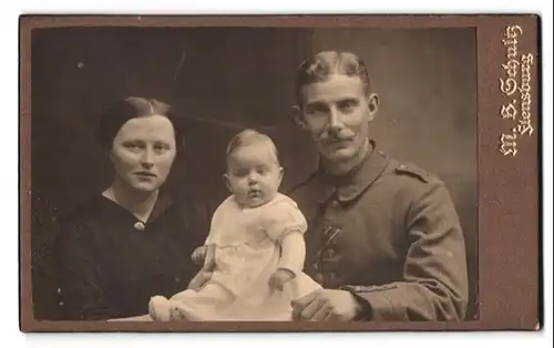 Fotografie M.B. Schultz, Flensburg, Bahnhofstr., Portrait Soldat in Feldgrau, Träger EK I., mit Familie