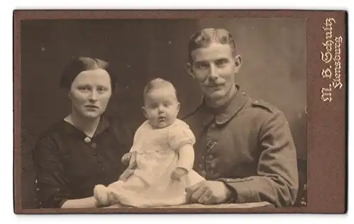 Fotografie M.B. Schultz, Flensburg, Bahnhofstr., Portrait Soldat in Feldgrau, Träger EK I., mit Familie