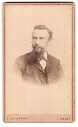 Fotografie C. Kortenkamp, Dresden, Portrait charmanter Herr mit Vollbart im Jackett