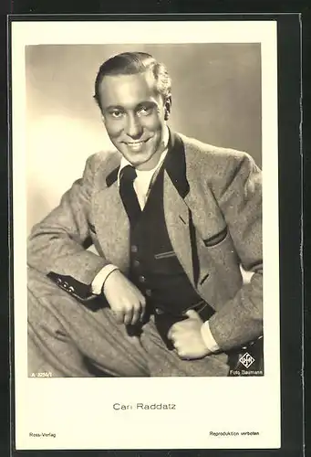 AK Schauspieler Carl Raddatz lächelnd mit aufgestützem Bein
