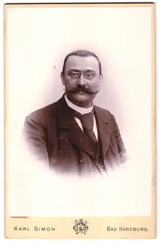 Fotografie Karl Simon, Bad Harzburg, Mann mit drahtiger Brille und gewaltigem Schnurrbart im Anzug