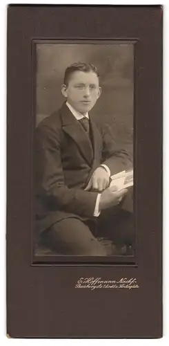 Fotografie E. Hoffmann Nachf., Dresden, Junger Mann mit Zwicker-Brille und Scheitelfrisur mit Buch in der Hand