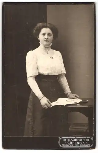 Fotografie Otto Schoenfeldt, Cöpenick, Schlossplatz, junge elegante Dame mit Bildband