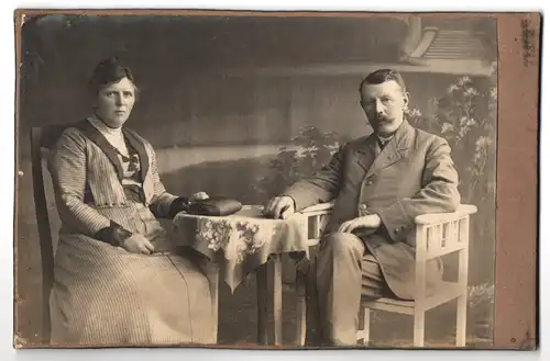 Fotografie Fotograf und Ort unbekannt, Mann und Frau am Tisch